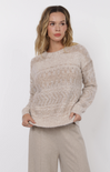 Woman wearing a beige sweater and pants on a white background