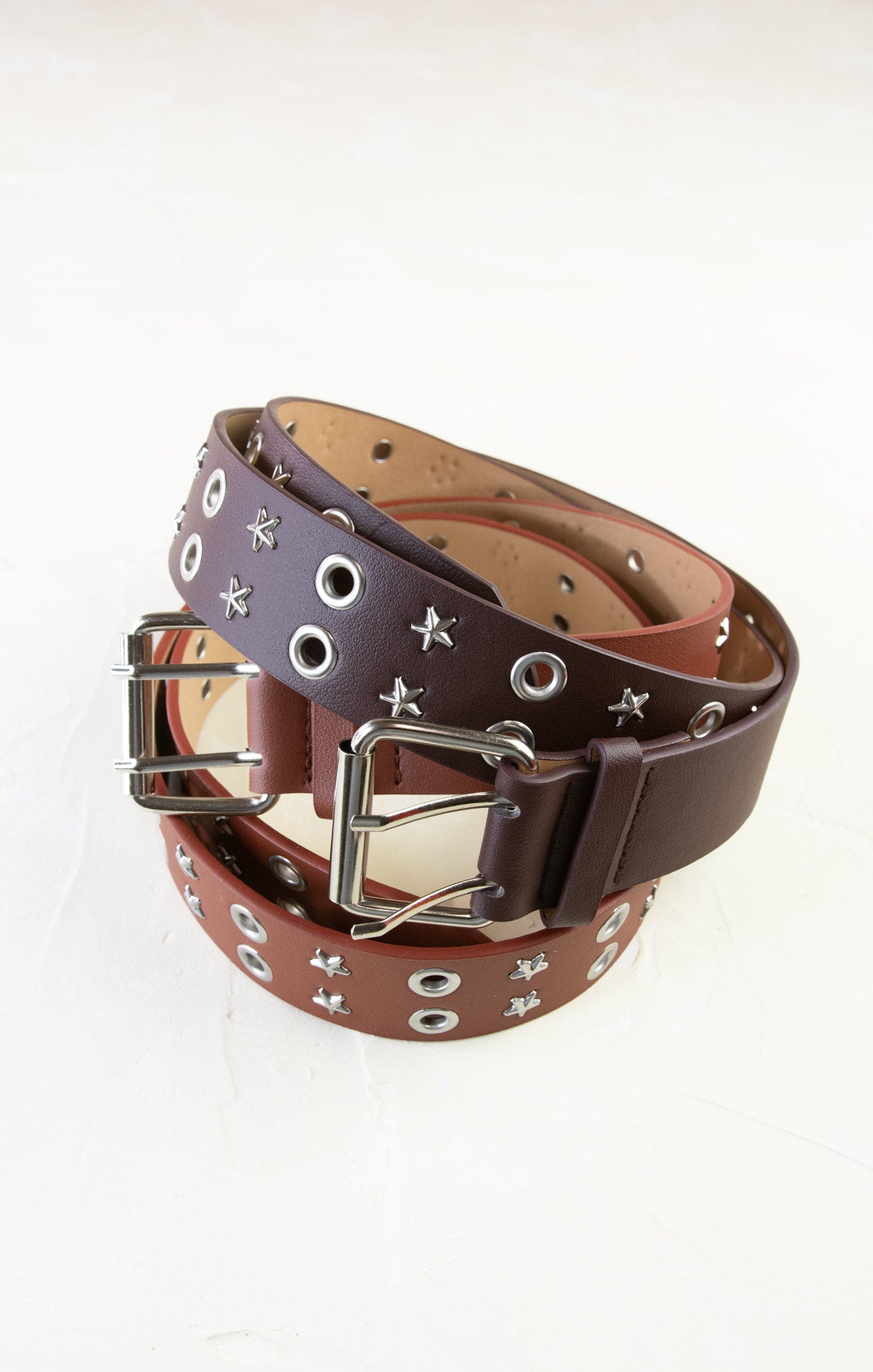 Brown leather belt with silver studs and buckle on a white background