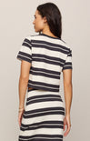 Woman wearing a black and white striped dress against a plain background