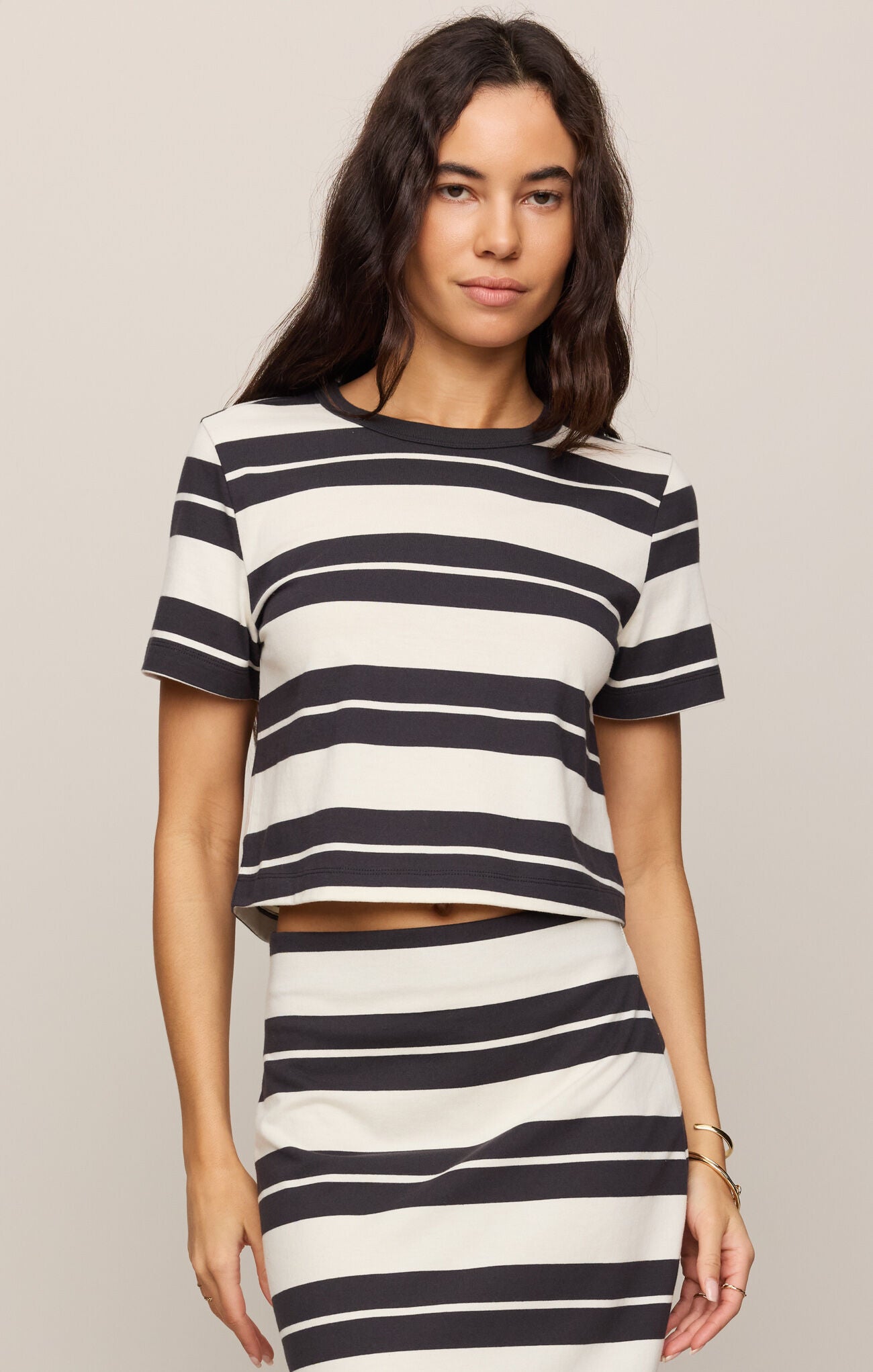 Woman wearing a black and white striped outfit on a plain background
