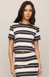 Woman wearing a black and white striped outfit on a plain background