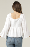 White blouse with bell sleeves worn by a person on a plain background