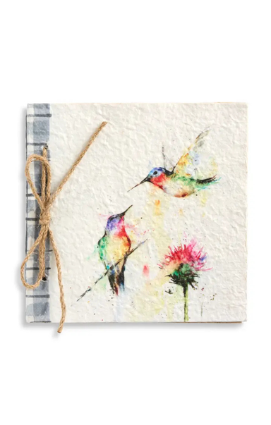 Notebook with watercolor design of hummingbirds and flowers, tied with twine on a white background