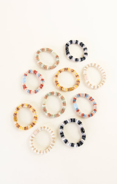 Set of colorful beaded hair ties on a white background