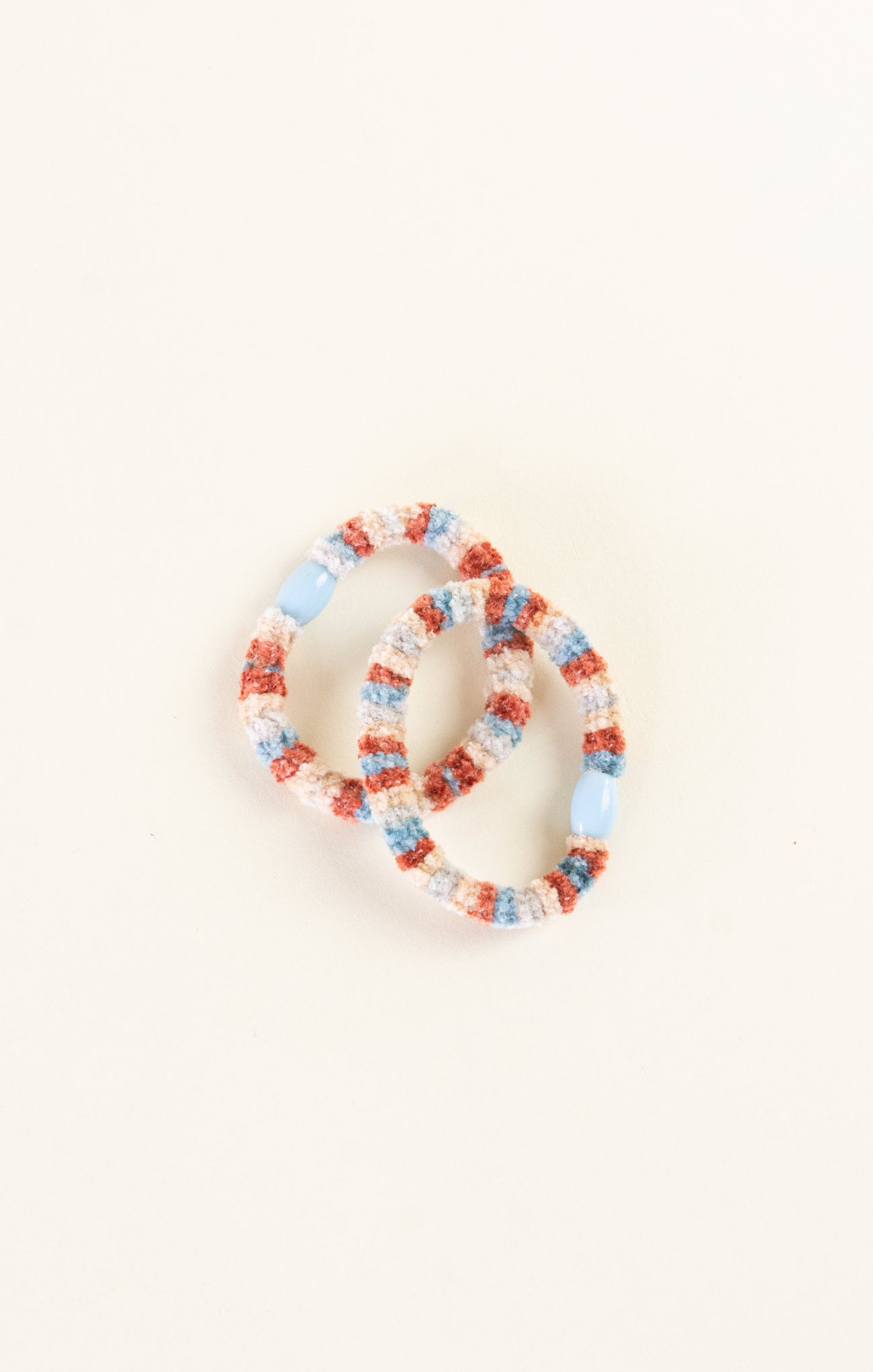 Set of colorful beaded bracelets on a light beige background