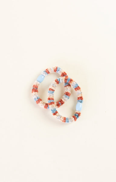 Set of colorful beaded bracelets on a light beige background