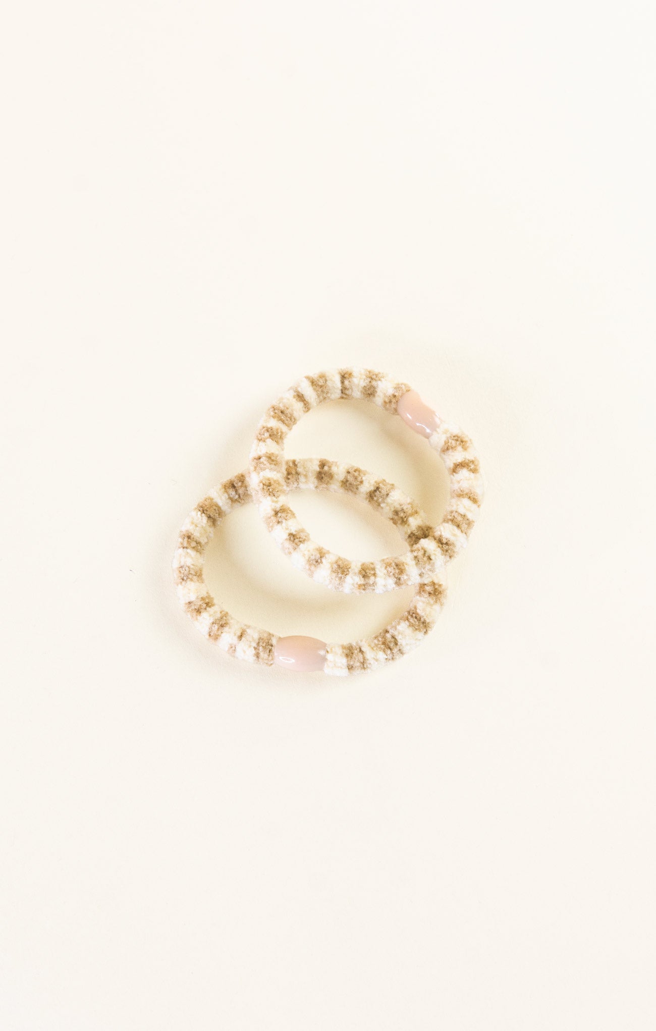 Set of pearl bracelets on a light beige background