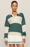 Woman wearing a green and white striped sweater with a matching skirt on a plain background