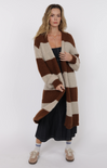 Woman wearing a long, striped brown and beige cardigan on a white background