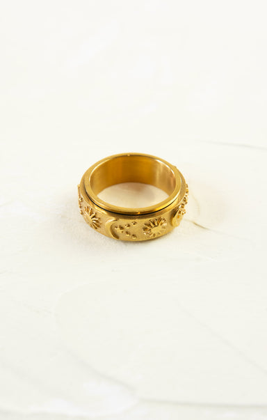 Gold ring with intricate design on a white background