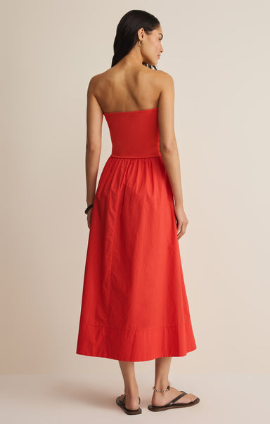 Woman wearing a strapless red dress against a beige background