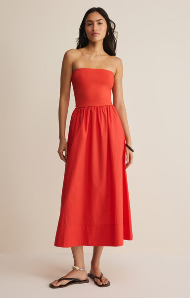 Woman wearing a strapless red dress against a beige background