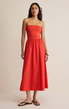 Woman wearing a strapless red dress against a beige background