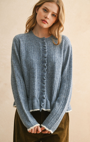Woman wearing a blue knitted cardigan against a beige background