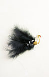 Black feathered hair clip with a gold and yellow swan design on a white background