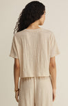 Woman wearing a beige textured top and pants on a beige background