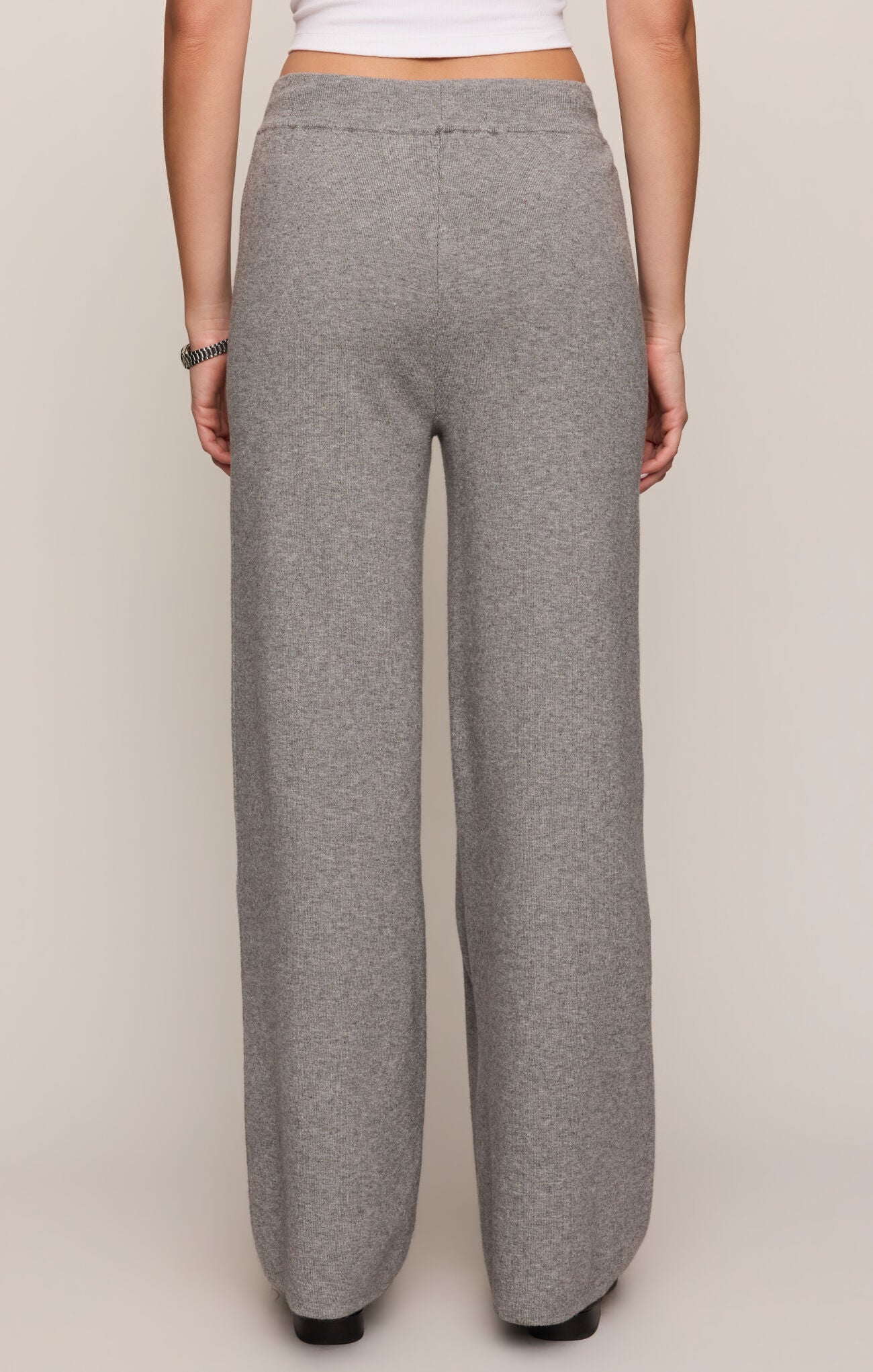 Gray sweatpants worn by a person on a plain background