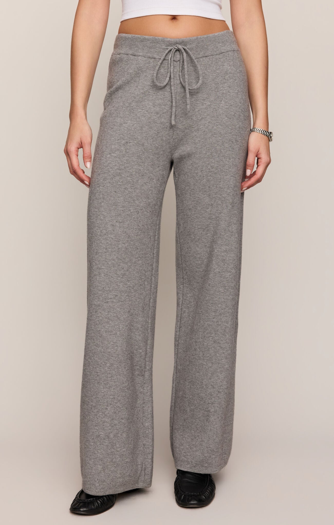 Person wearing gray sweatpants on a plain background