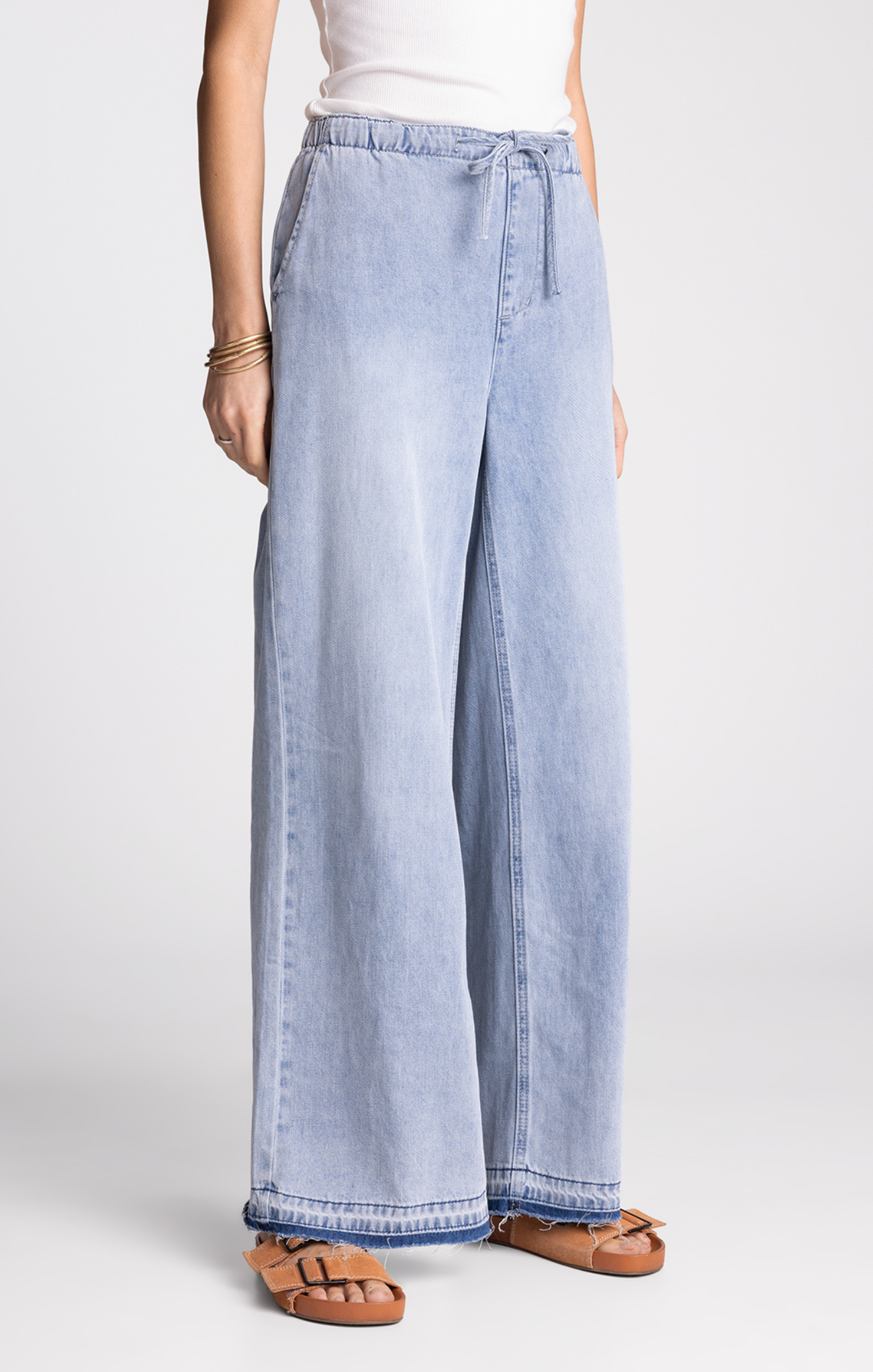 Light blue wide-leg jeans worn by a person on a white background