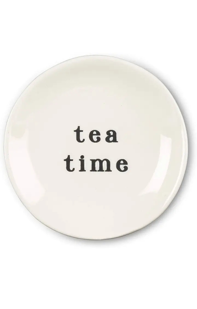 A round off-white ceramic plate with the words 'tea time' printed in a black serif font in the center, set against a plain white background.