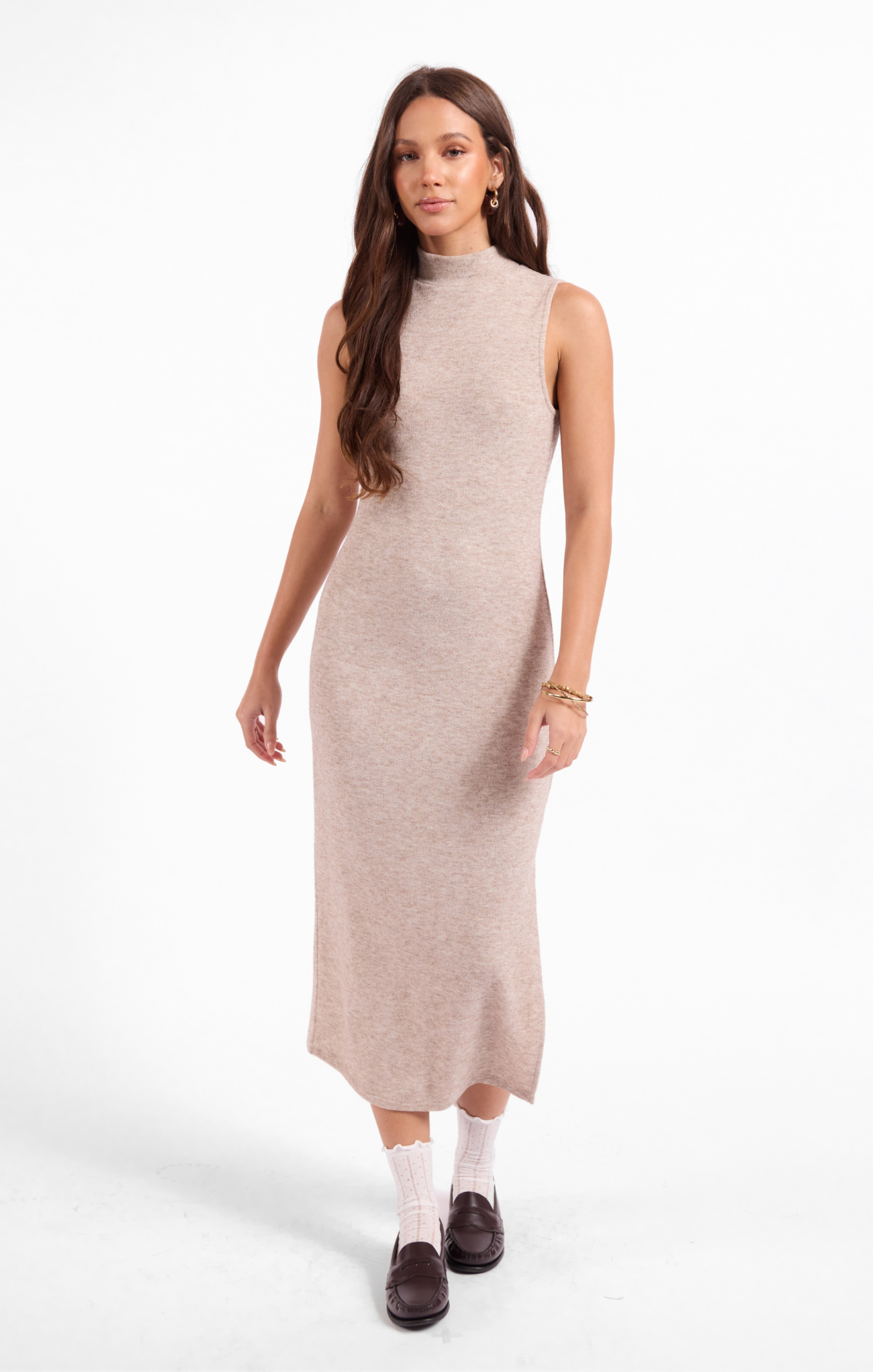 Woman wearing a beige sleeveless dress on a white background