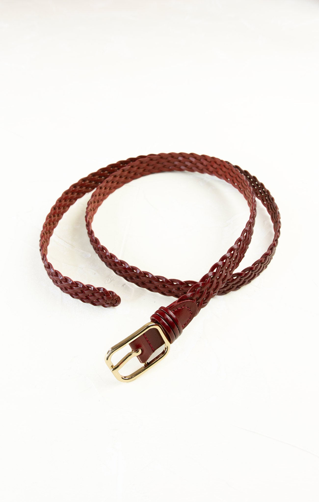 Brown braided belt with a gold buckle on a white background