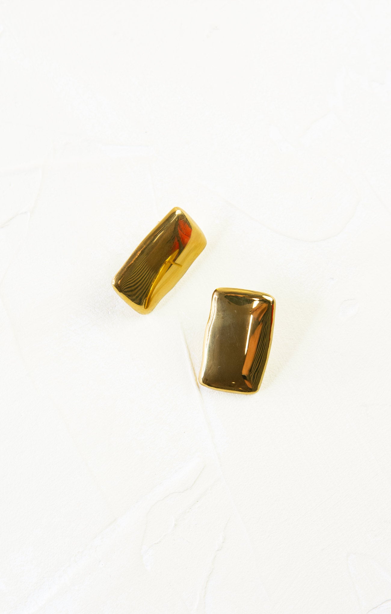 Gold rectangular earrings on a white background