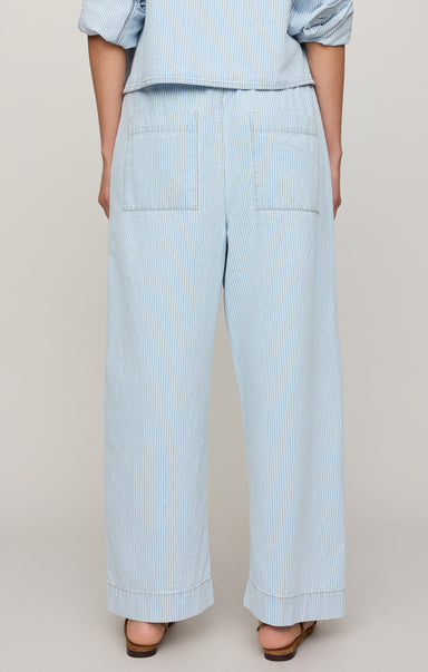 Light blue striped pants worn by a person on a beige background