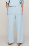 Light blue striped pants worn by a person on a beige background