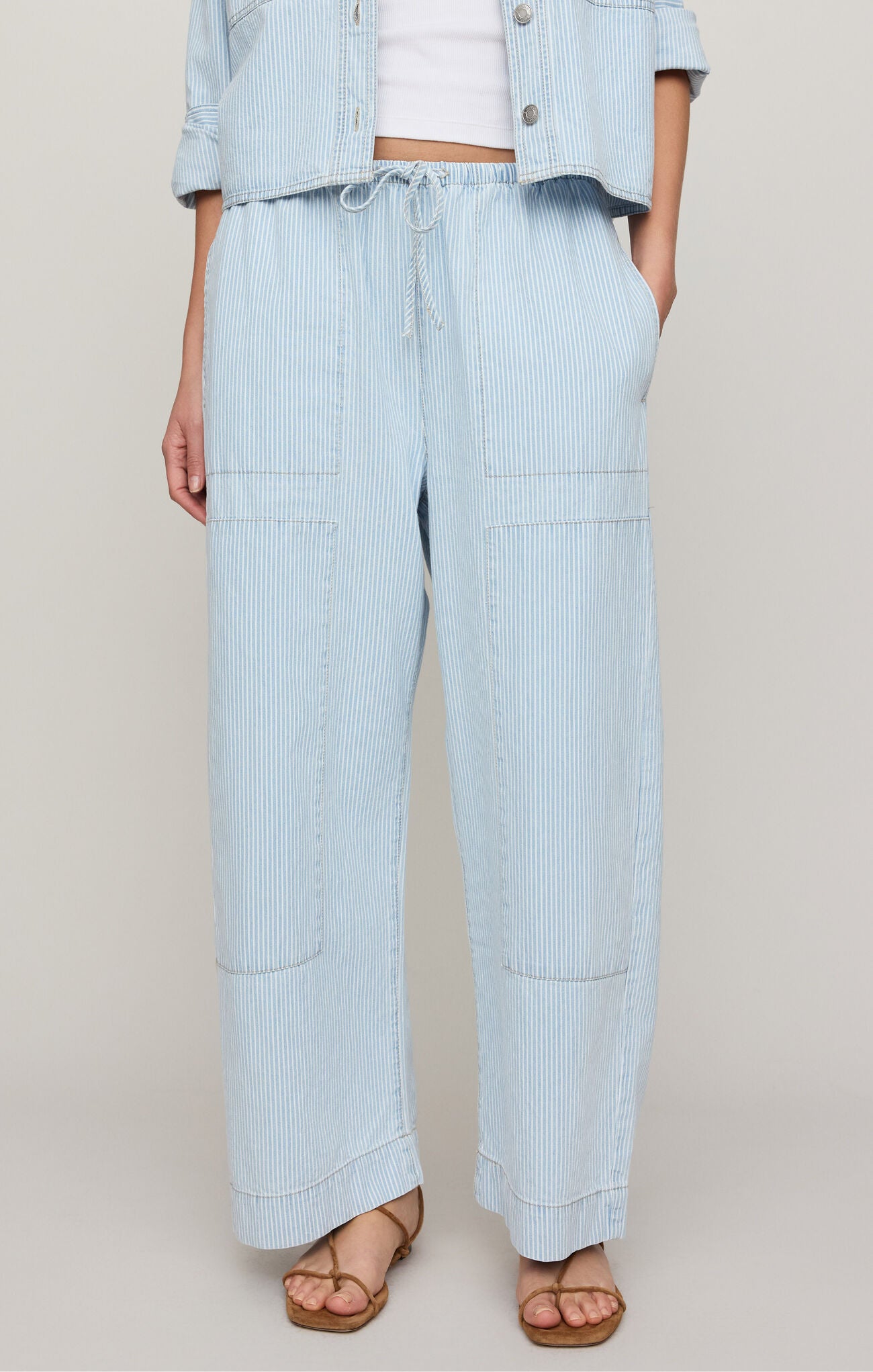 Light blue striped pants worn by a person on a plain background