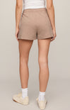 Person wearing beige shorts on a plain background