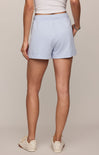 Light blue shorts worn by a person on a beige background