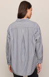 Person wearing a gray and white striped shirt against a beige background