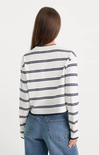 Woman wearing a striped long-sleeve shirt and jeans on a white background
