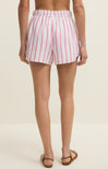 Person wearing pink and white striped shorts on a plain background
