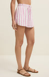 Person wearing pink and white striped shorts on a beige background