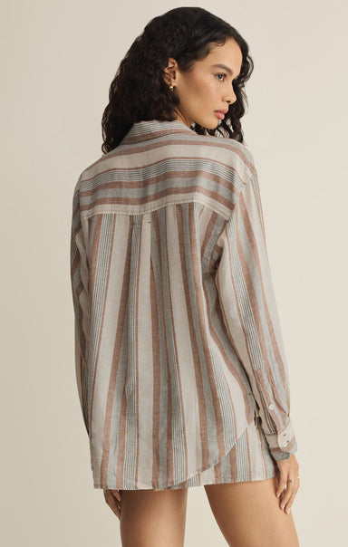 Woman wearing a striped shirt against a beige background