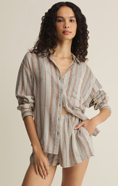 Woman wearing a striped shirt and shorts set on a beige background