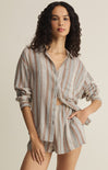 Woman wearing a striped shirt and shorts set on a beige background