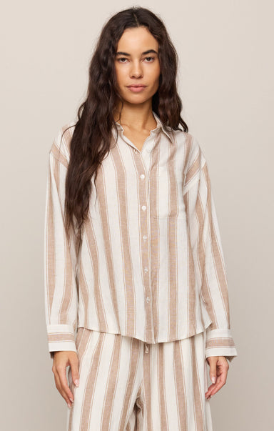 Woman wearing a striped pajama set against a plain background