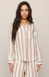 Woman wearing a striped pajama set against a plain background
