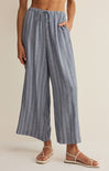 Person wearing blue striped wide-leg pants on a beige background