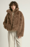 Person wearing a brown fluffy jacket on a white background