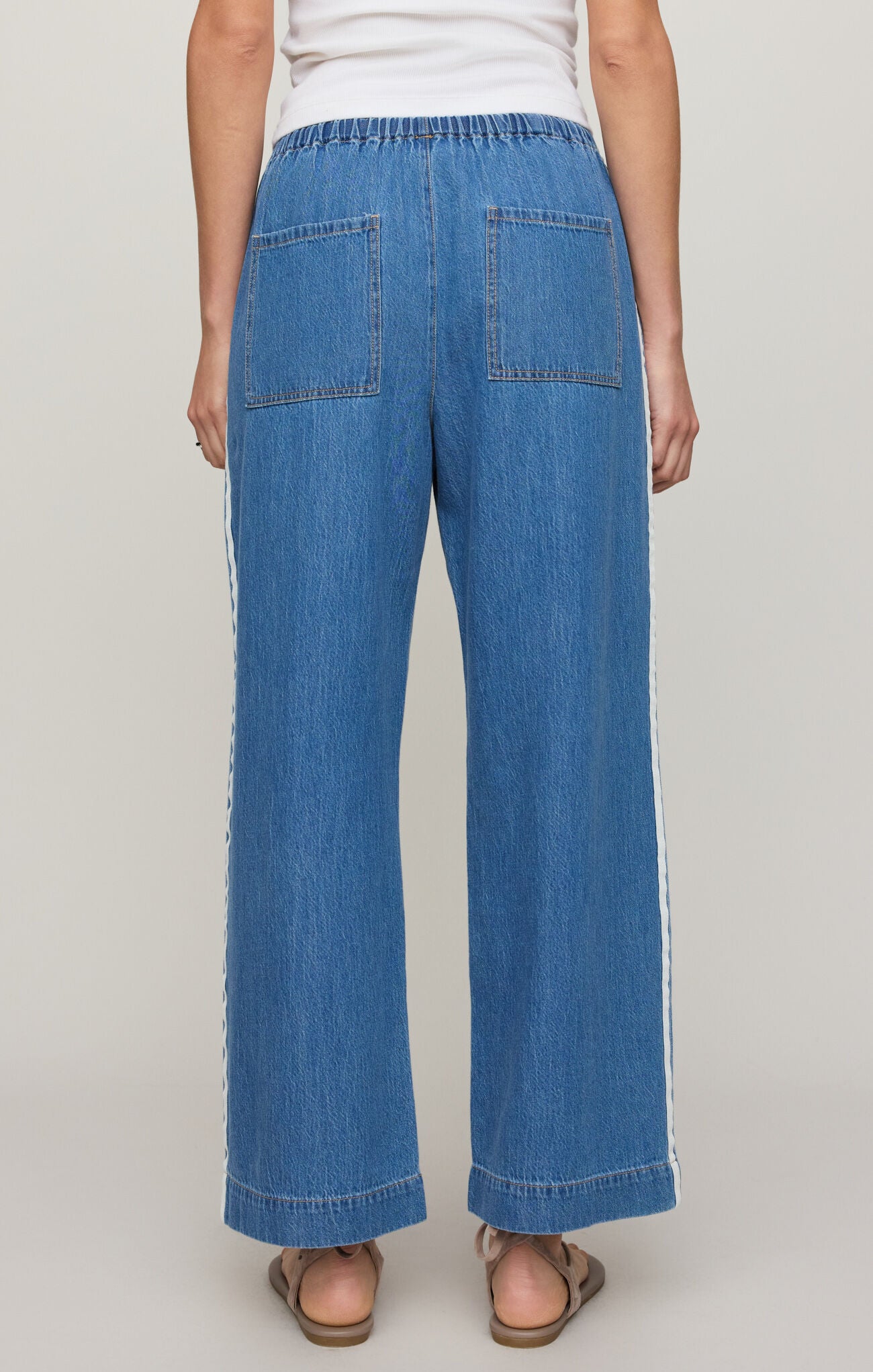 Person wearing blue denim pants on a plain background