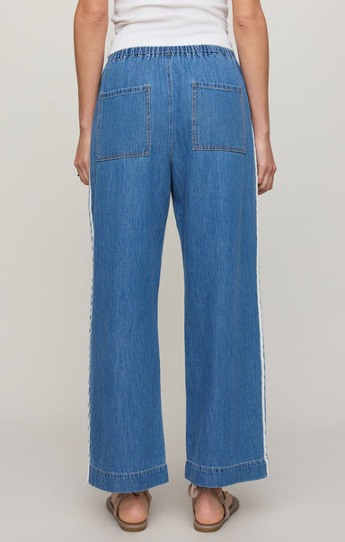 Person wearing blue denim pants on a plain background