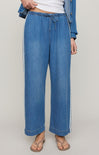 Blue jeans worn by a person on a plain background