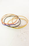 Set of colorful beaded bracelets on a light background