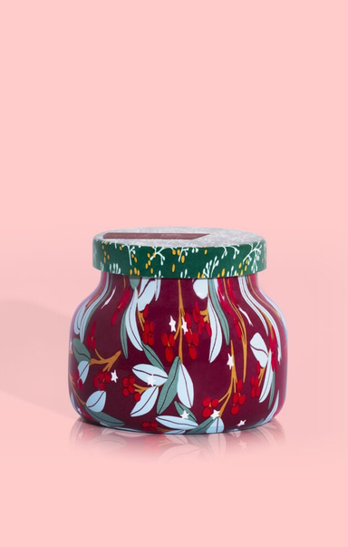 Decorative glass jar with floral design on a pink background