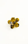 Flower-shaped object with black and yellow pattern on a white background
