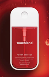 Touchland Power Essence bottle on a red background